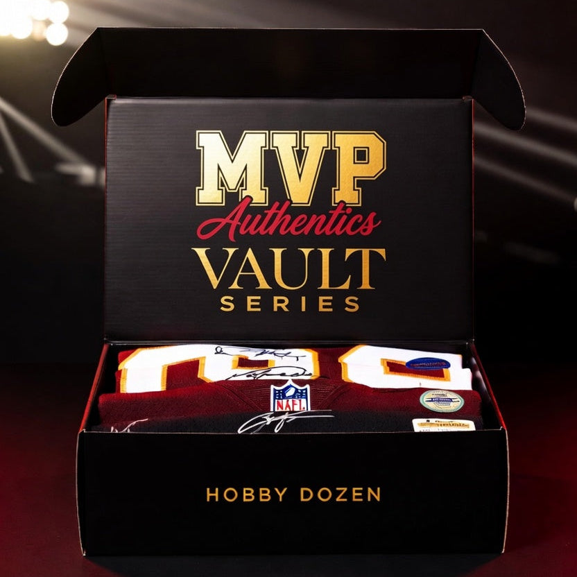 An open black presentation box labeled 'MVP Authentics Vault Series' and 'Hobby Dozen' on a dark stage-like background with spotlighting. Inside the box is a football jersey with large gold and white numbers, along with small authentication seals.